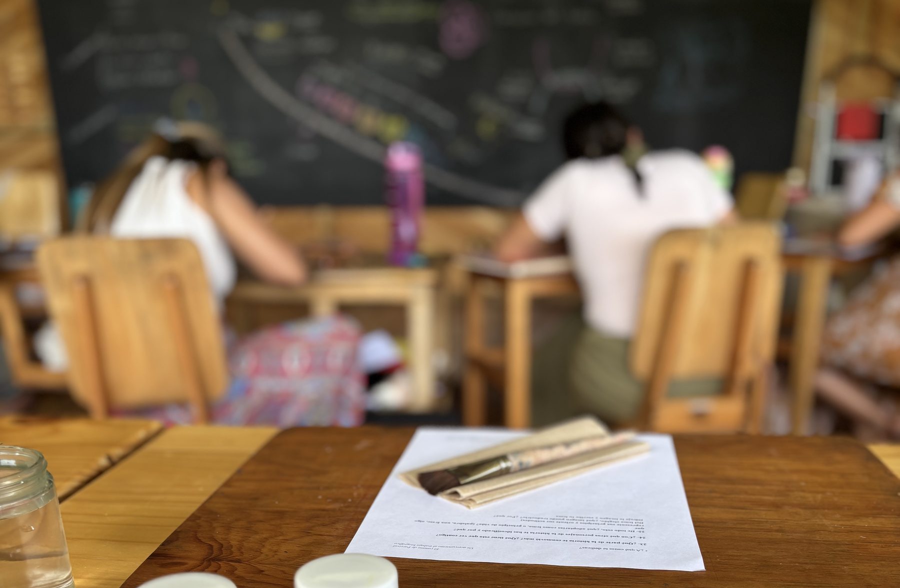 Participantes trabajando en un aula Waldorf, con el pizarrón de las fases de fondo